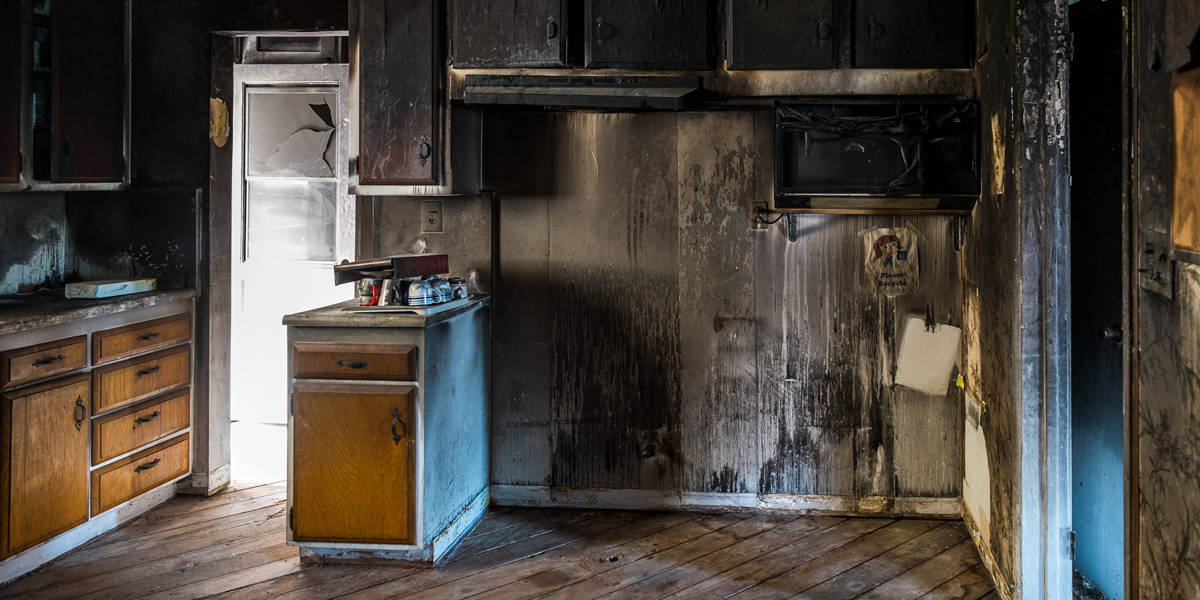 Smoke damage cleanup with restoration equipment in a damaged room